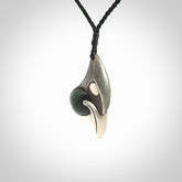 This is a hand carved Sterling Silver Saddleback, Kokako, bird pendant with British Columbian Jade insert. This is a medium sized necklace and is provided with an adjustable black cord.